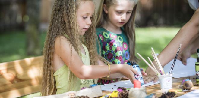 Due bambini dipingono con i colori acrilici