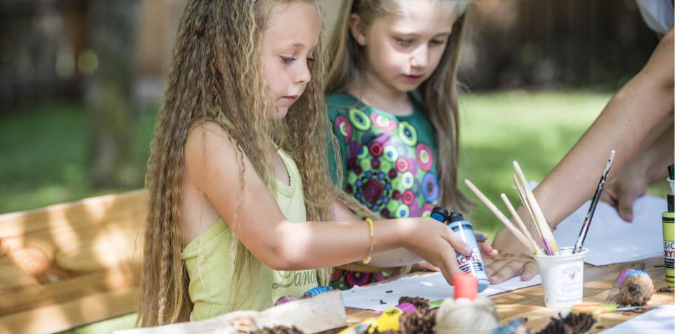 Due bambini dipingono con i colori acrilici