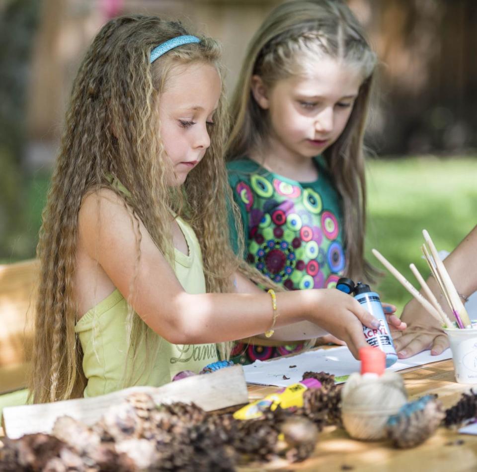 Due bambini dipingono con i colori acrilici