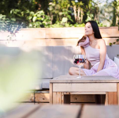 A woman is lying on a deck chair in the garden