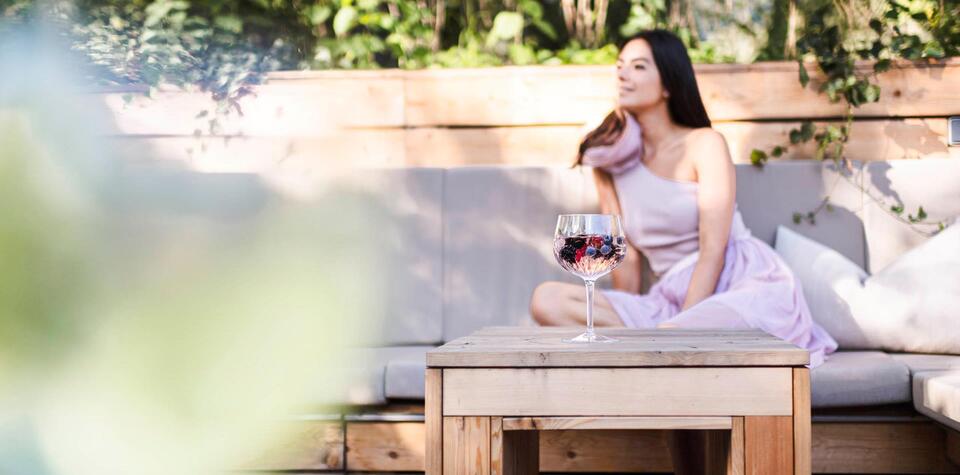 Eine Frau liegt auf dem Liegestuhl im Garten