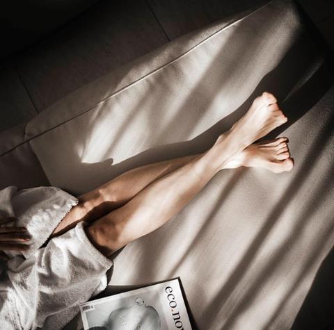 Una donna in accappatoio su una chaise longue