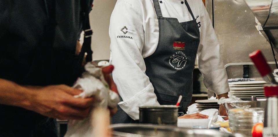Two chefs are working together on the preparation of several dishes