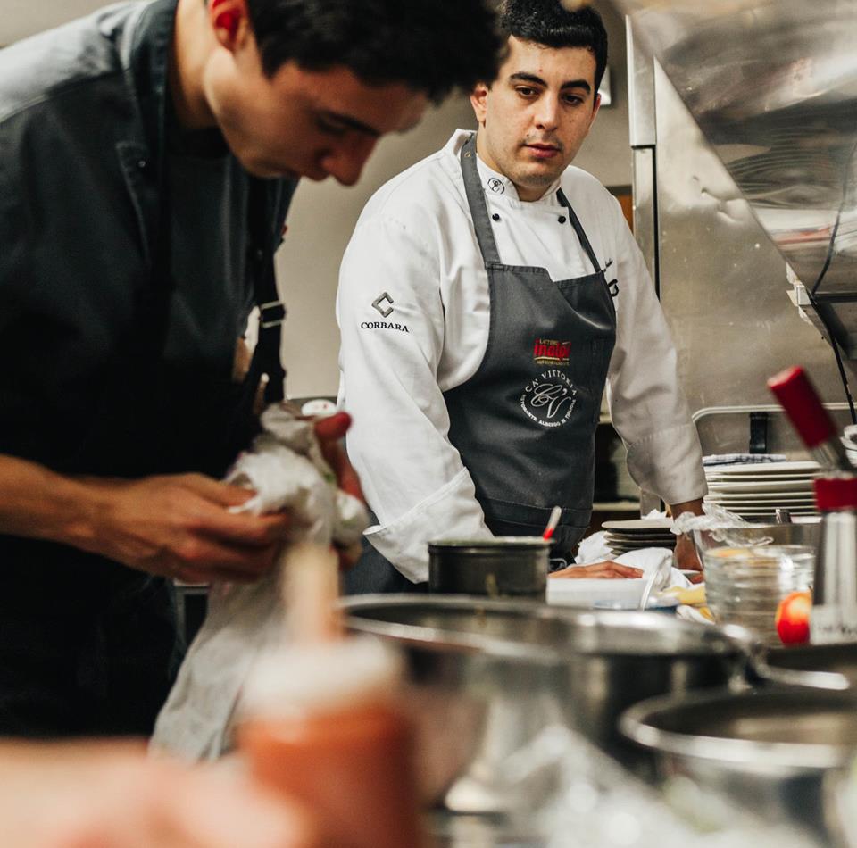 Zwei Köche arbeiten gemeinsam an der Zubereitung mehrerer Speisen