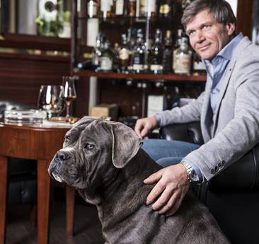 A man and a dog are sitting at a table
