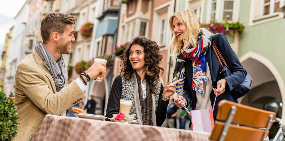 Two men and a woman are sitting at a table in the city of Sterzing