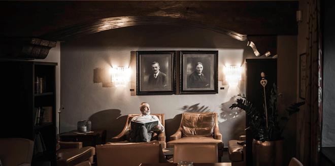 A man is sitting on a couch in the Stafler Hotel