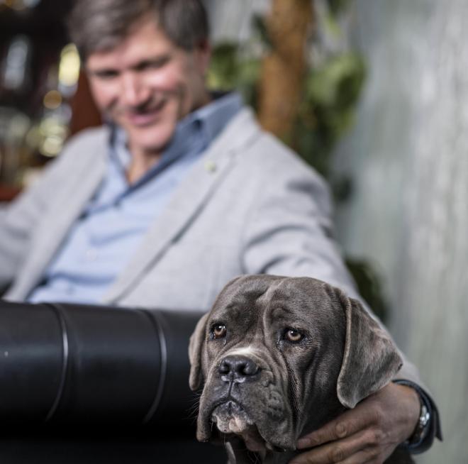 Ein Mann und ein Hund sitzen an einem Tisch