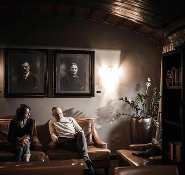 A man is sitting on a couch in the Stafler Hotel