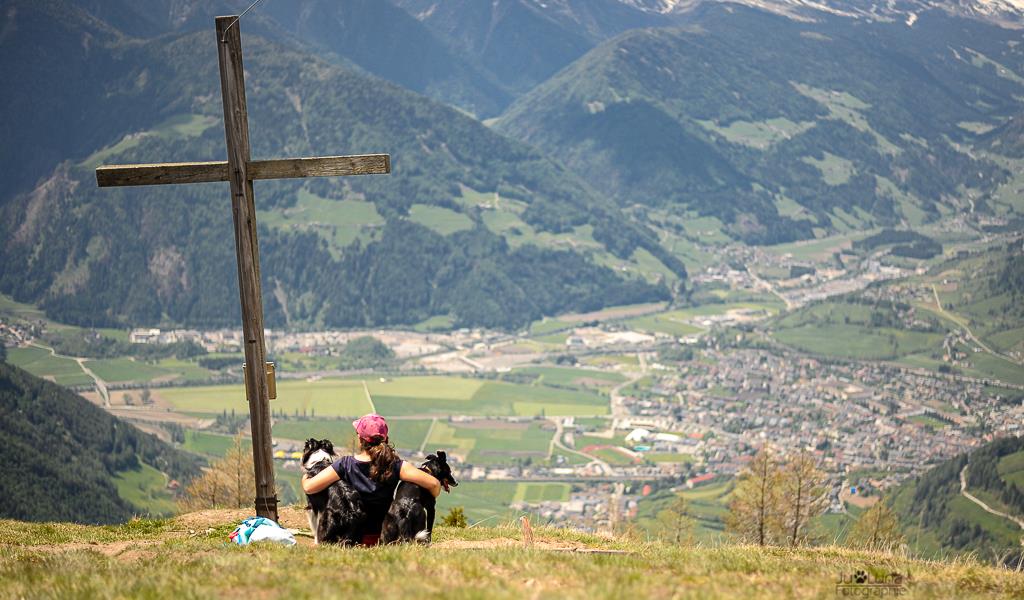 Frau mit zwei Hunden am Gipfelkreuz