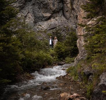 una coppia in una gola con un torrente di montagna