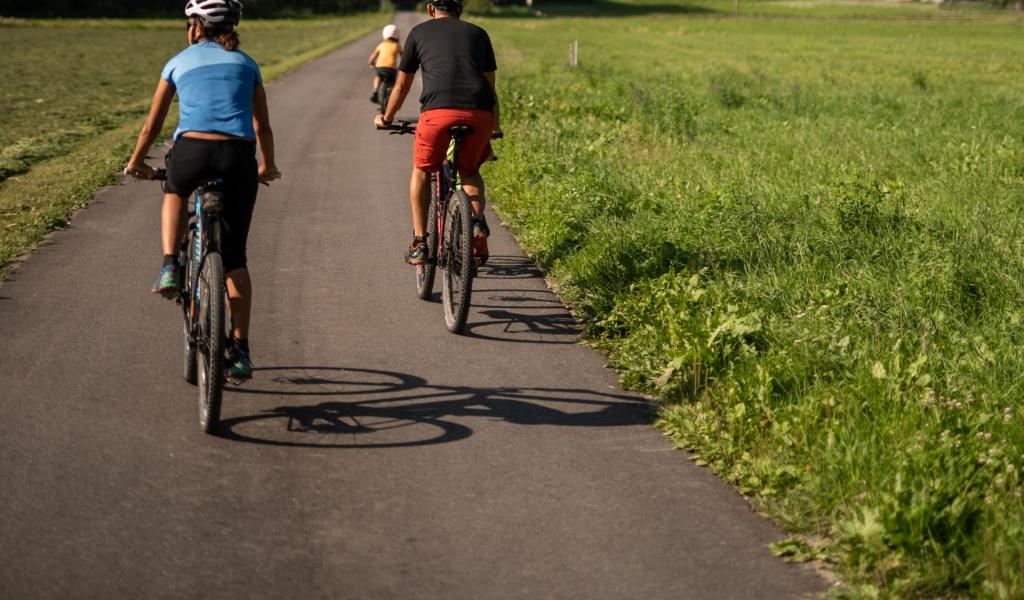Ein Mann, eine Frau und ein Kind mit Fahrrädern auf einem Fahrradweg