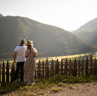 Ein Mann und eine Frau blicken auf eine Berglandschaft