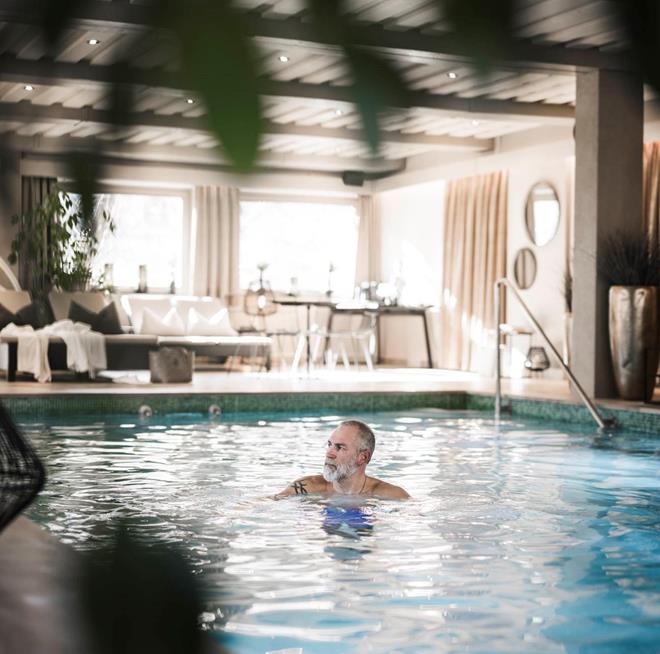 A man is swimming in the swimming pool