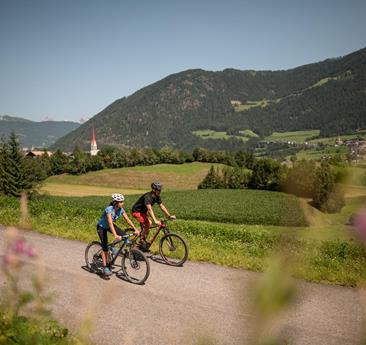Ein Mann und eine Frau mit Fahrrädern auf einem Fahrradweg