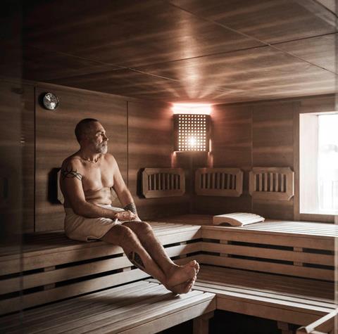 A man is sitting in a Finnish sauna
