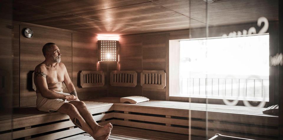 A man is sitting in a Finnish sauna