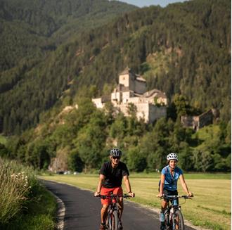 A man and a woman with bicycles on a bike path