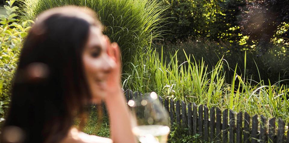 Eine Frau sitzt auf einer Bank mit einem Glas Wein