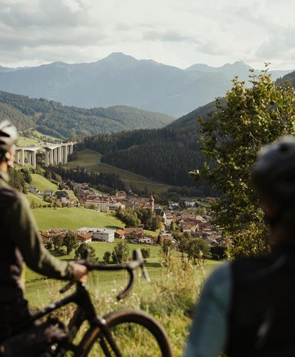 Zwei Fahrradfahrer blicken auf die Stadt Sterzing