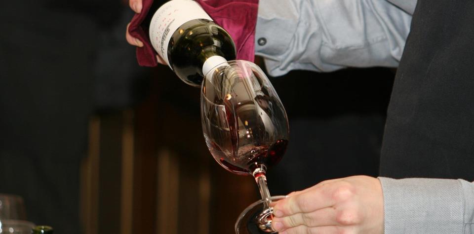 A sommelier pours a glass of wine