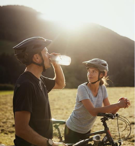 Two people are riding bicycles