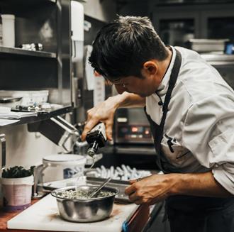 Ein Koch bereitet ein Gericht zu