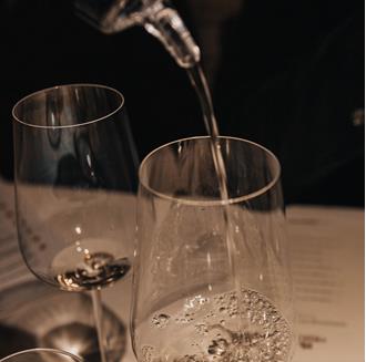 Una sommelier versa un bicchiere di vino