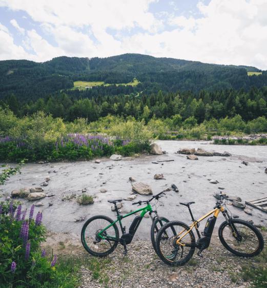 Two e-bikes at the shore of a stream