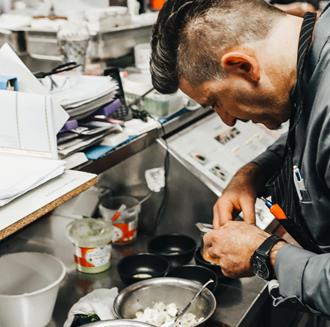 Ein Koch bereitet ein Gericht zu