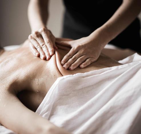 Eine Frau führt bei einer Frau eine Massage durch
