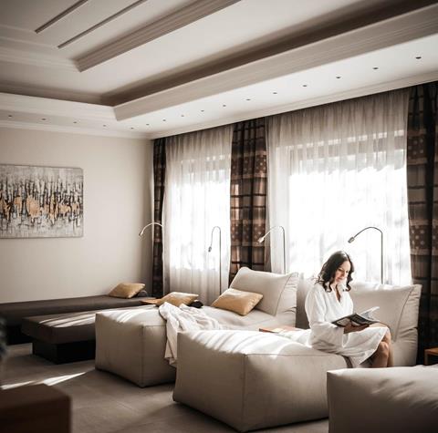 Una donna è seduta su una chaise longue nella sala relax