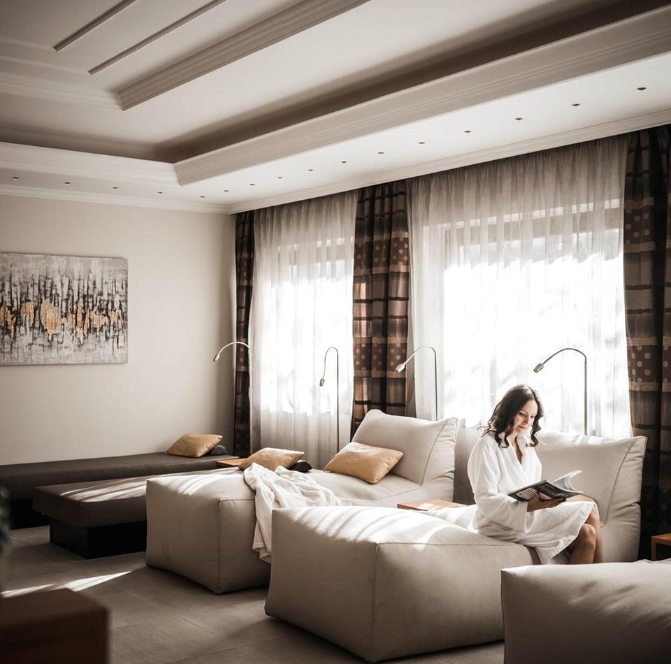 Una donna è seduta su una chaise longue nella sala relax