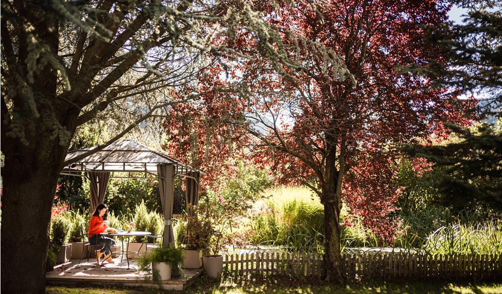 Una donna è seduta nel giardino dell’Hotel Stafler