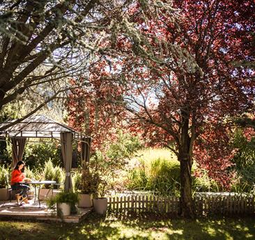 A woman sits in the garden of Hotel Stafler