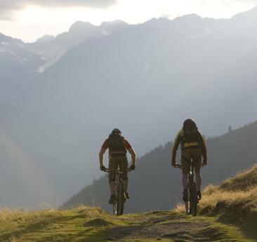 Zwei Männer mit ihren Fahrrädern auf einer Downhill Strecke