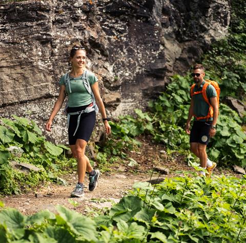 A couple is hiking on a mountain path