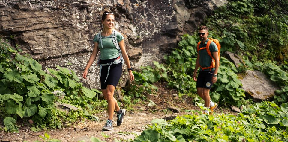 A couple is hiking on a mountain path