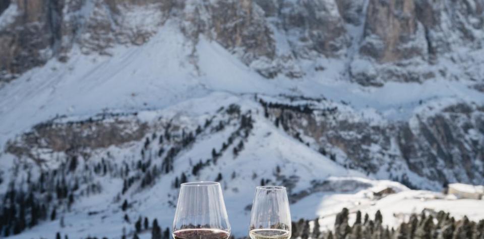 Ein gedeckter Holztisch vor verschneiter Bergkulisse