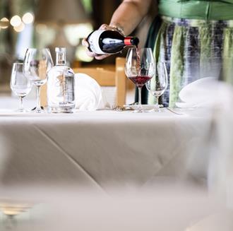 A woman pours a glass of red wine