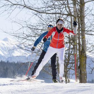 A man and a woman cross-country skiing