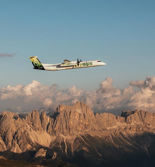A SkyAlps airplane flies over the Dolomites