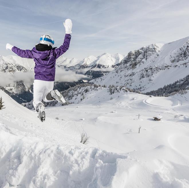 A woman jumping in ski boots
