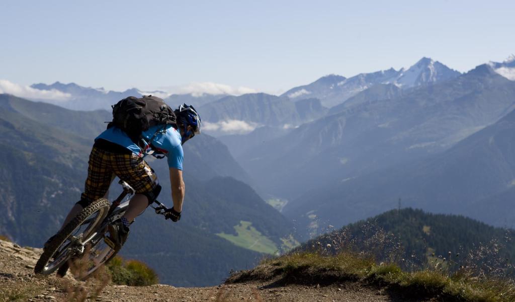 Ein Mann mit seinem Fahrrad auf einer Downhill Strecke