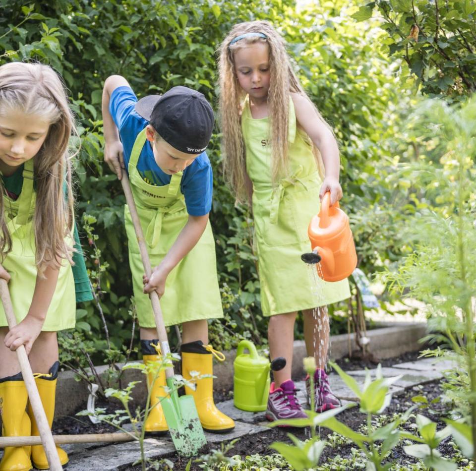 Tre bambini che fanno giardinaggio