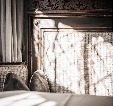 Un dettaglio del rivestimento in legno nell’Hotel Stafler, con legno scuro finemente intagliato e una luce morbida