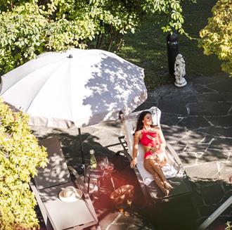 Eine Frau liegt auf dem Liegestuhl im Garten