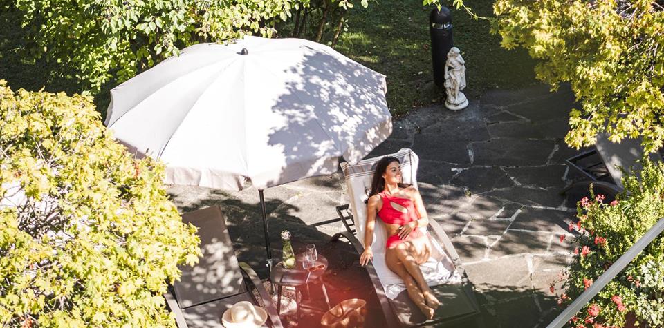 A woman is lying on a deck chair in the garden