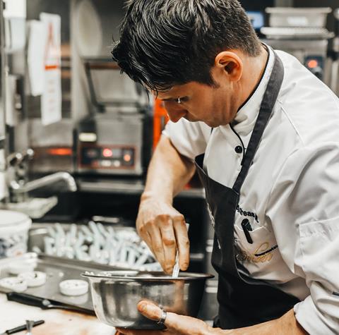 Un cuoco prepara un piatto