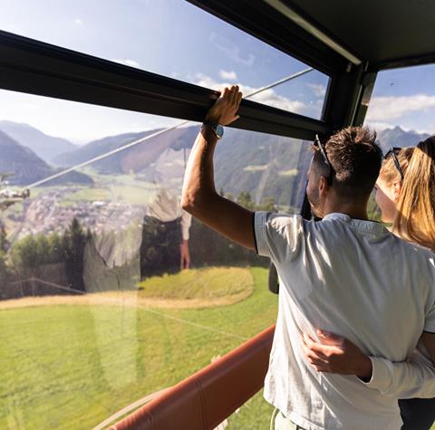 A couple looks out from a cable car